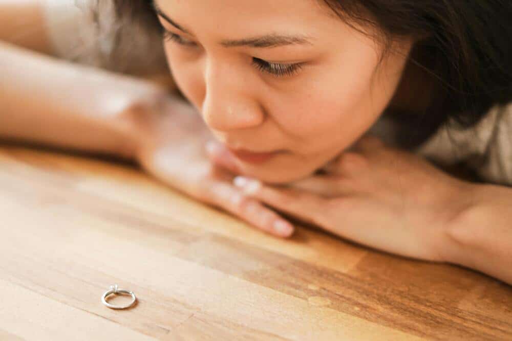 Sad woman looking at an engagement ring.